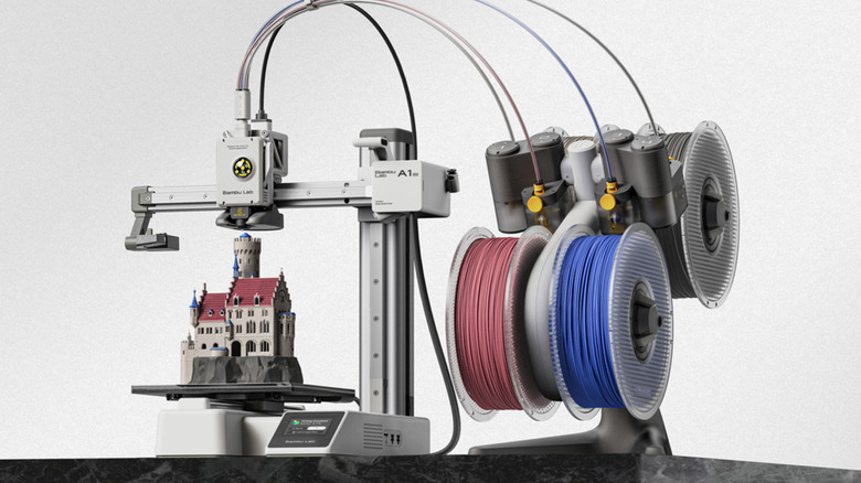 Bambu Lab A1 Mini 3D printer creating a miniature castle with multicolor filament spools attached.