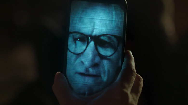 Scully holds up her phone to see Langley