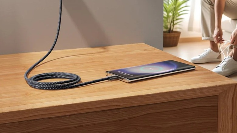 A Lisen 240W USB-C cable charging a smartphone on a wooden dresser