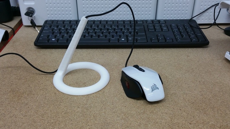 A white mouse cable holder on desk