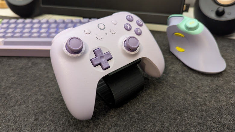 A pink controller on a 3D printed stand on desk