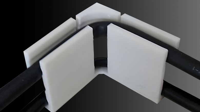 A cable corner securing power cables on a black gradient background