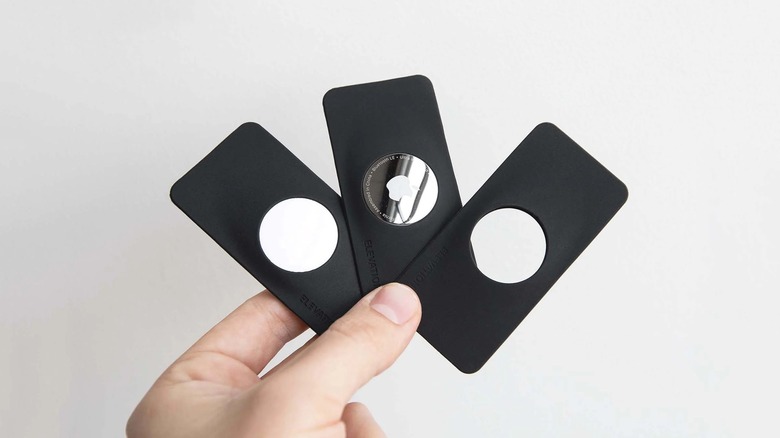 Close-up of a person holding three TagVault AirTag Wallet Holders