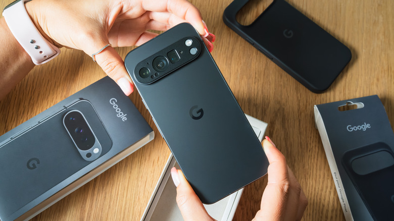 Close-up of a person's hands as they hold a new Google Pixel smartphone after unboxing it