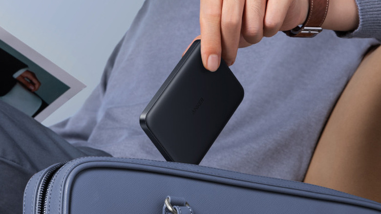 An Anker MagGo MagSafe Power Bank being put into a suitcase