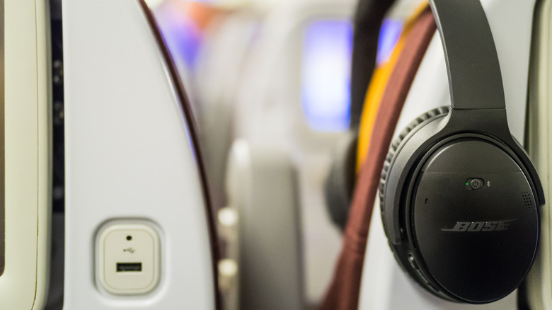 Bose headphones on an airplane seat.