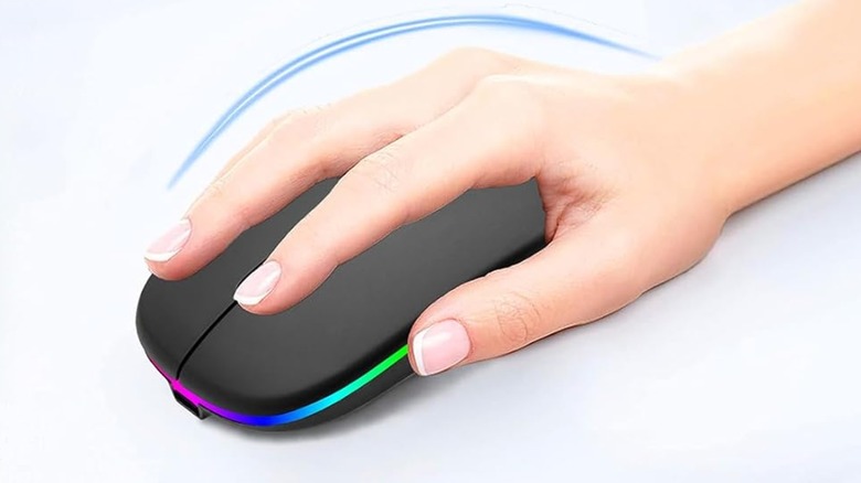 A hand resting atop a black Aikokok Wireless Bluetooth Rechargeable LED Laptop Mouse with its rainbow LED strip on