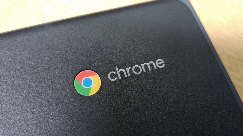 A close-up shot of the Google Chromebook logo on the corner of a black Chromebook