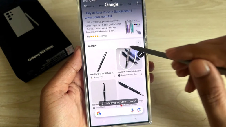 Hand holding phone and S Pen to draw a circle on the screen to search