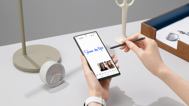 Hand holding S Pen and Galaxy phone