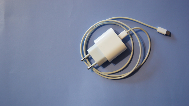 A smartphone charger against a light blue surface.