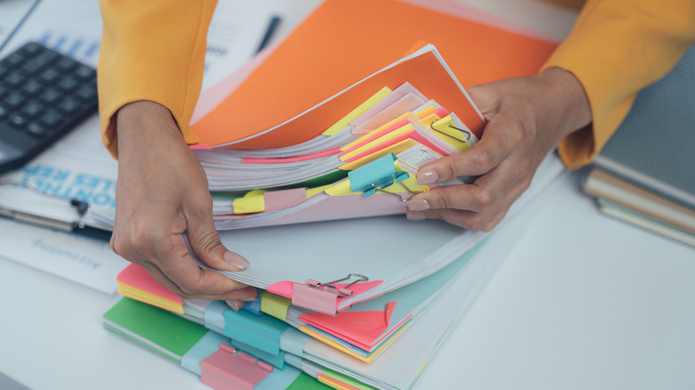 A person pulling documents out of a file folder.