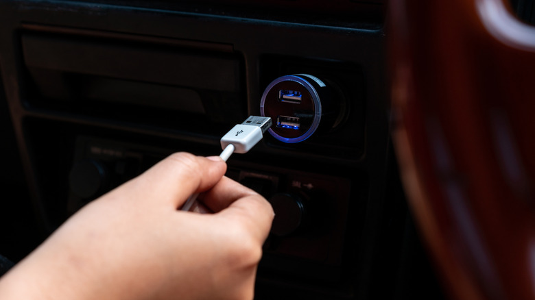 a hand plugging a USB cable into a USB port on the back of a smart tv