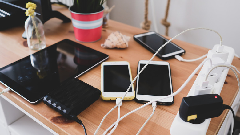 Various devices on a desk plugged into a power strip with wires everywhere