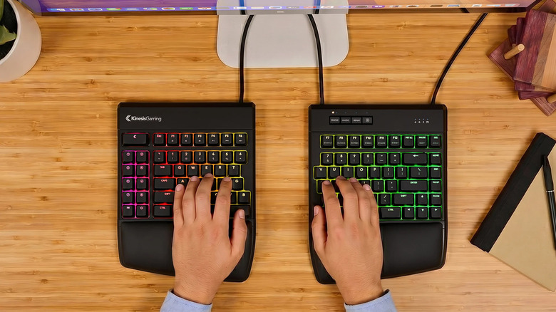 Close-up of hands typing on a KINESIS ergonomic keyboard separated into two halves