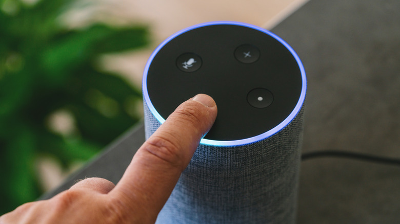 Clos- up of a finger touching a button on an Amazon Echo device