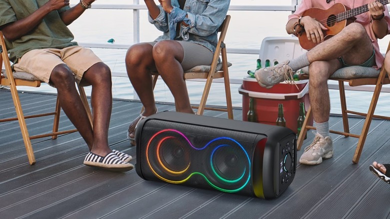 The Jauyxian Y20-T portable speaker on its side on the floor, with people around it.