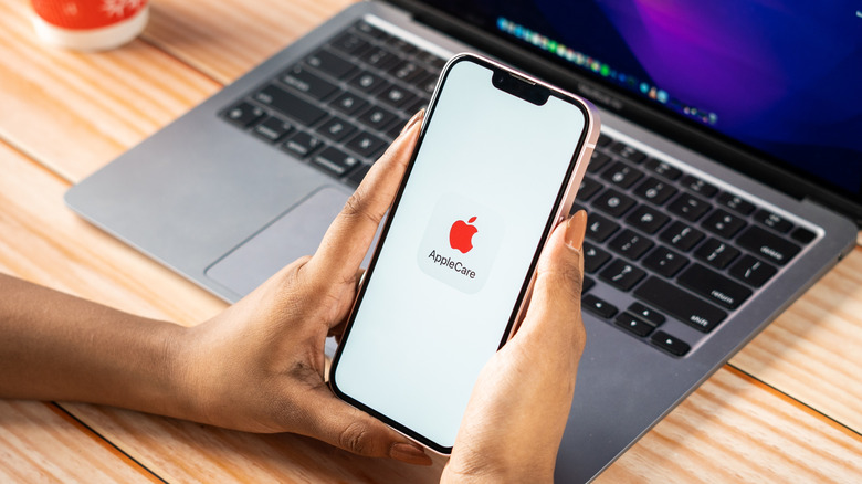 Person holding an iPhone that is displaying the AppleCare logo