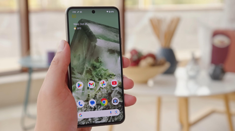 Hand holding Android phone on home screen
