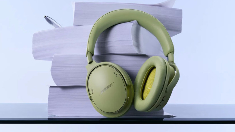 A set of Eucalyptus Green headphones in front of stacks of paper.