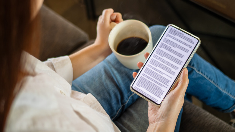 Reading an eBook on an iPhone with a cup of coffee