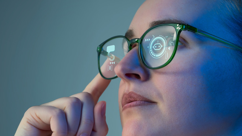 A woman tapping on the sides of smart glasses.