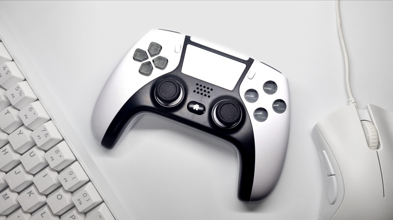 White gaming controller with mouse and keyboard nearby.