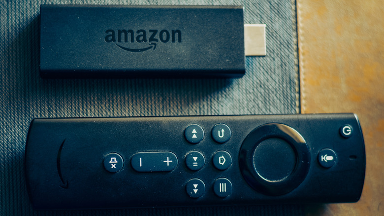 An Amazon Fire TV Stick placed next to its remote.