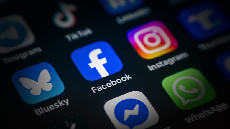 Facebook app icon in focus on a smartphone screen surrounded by other social media apps.