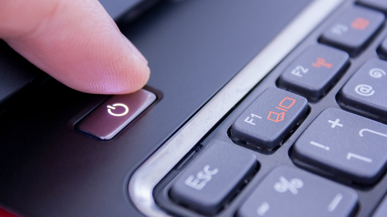 Finger pushing laptop power button