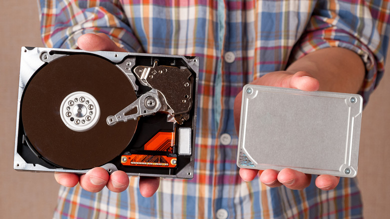 Person holding HDD and SSD
