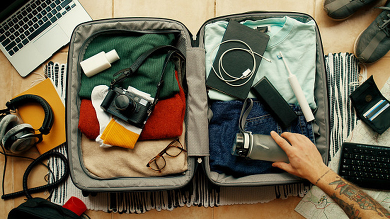 A man packing a suitcase for a trip.