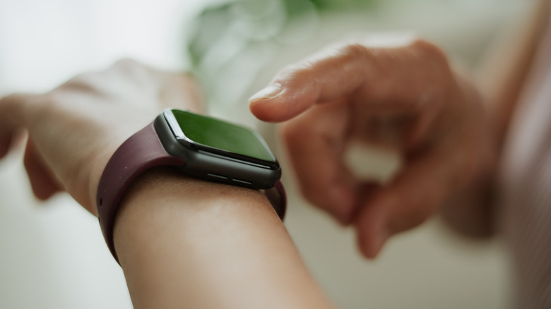 Close up of someone interacting with a non-descript smartwatch.