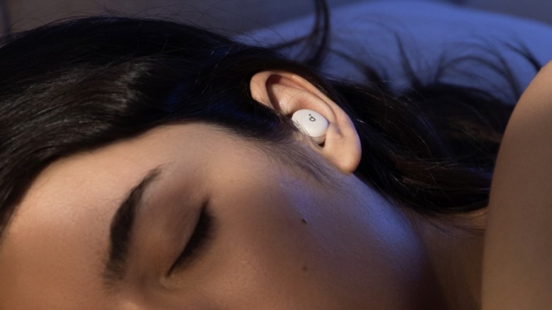 A woman wearing Anker's A30 earbuds while sleeping.