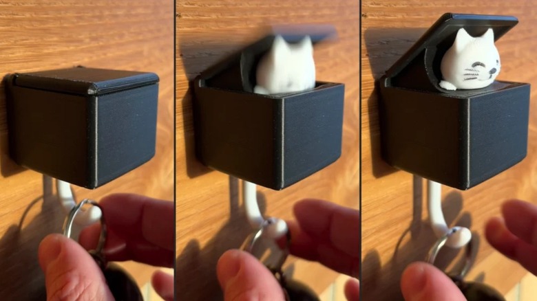 A wall mounted Cat key hook showing it's different movements as a key is hooked onto its tail