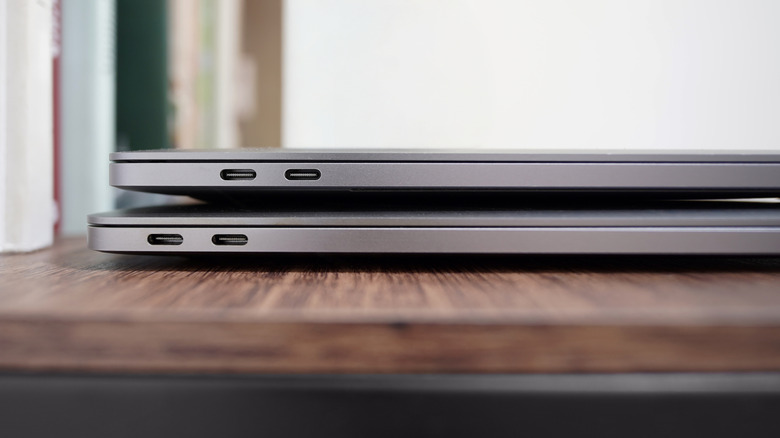 two macbooks piled together with usb c ports visible