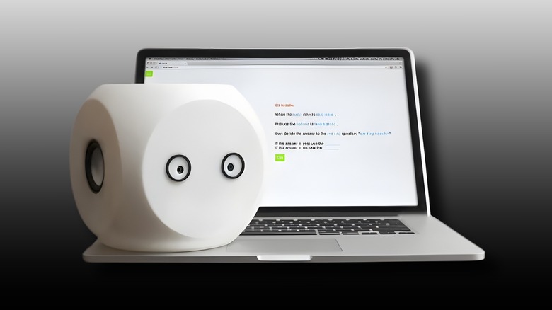 Noodle the Robot sat on an Apple Macbook with a black and white background