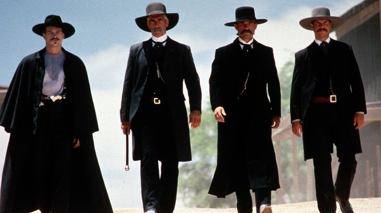 Doc Holiday (Val Kilmer), Virgil (Sam Elliott), Wyatt (Kurt Russell) and Morgan (Bill Paxton) walking side by side in Tombstone