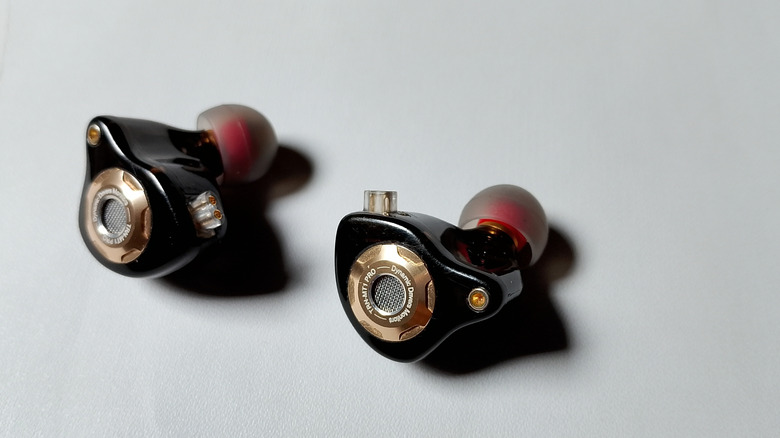 A closeup of a pair of IEMs sitting on a table with no wires plugged into them