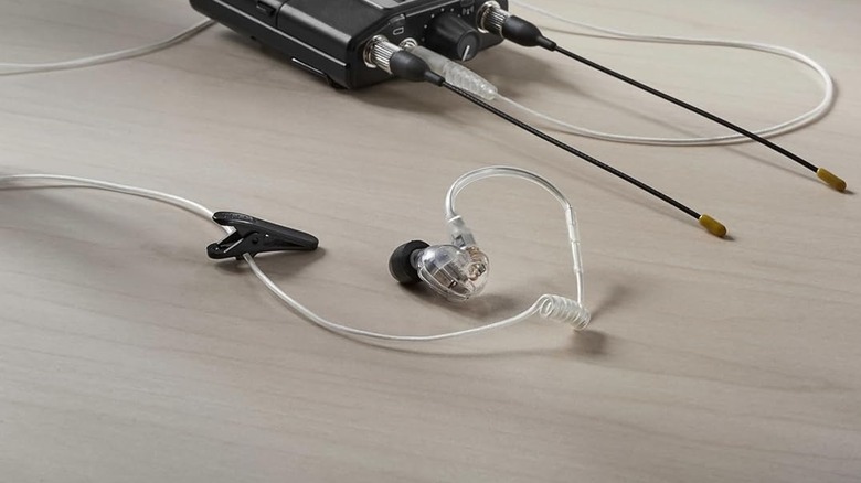 A closeup of the Shure SE425 Pro IEM sitting on a table next to a wireless pack