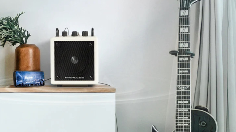 The AirPulse AU-4 Compact set up next to a guitar.