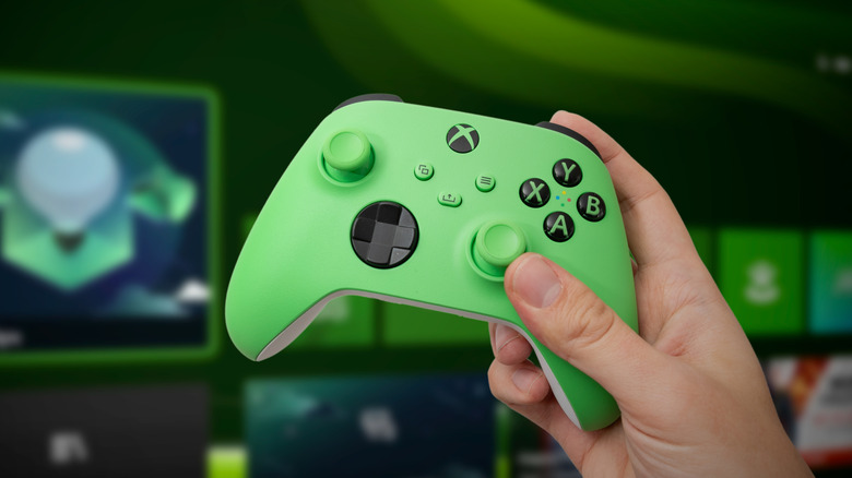 Green Xbox Series X controller in front of a TV displaying Xbox Series X dashboard