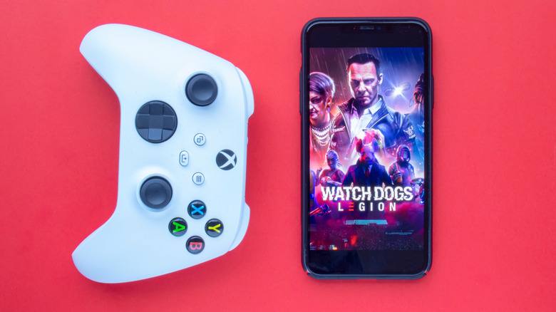Xbox controller next to a phone with Watch Dogs Legion displayed