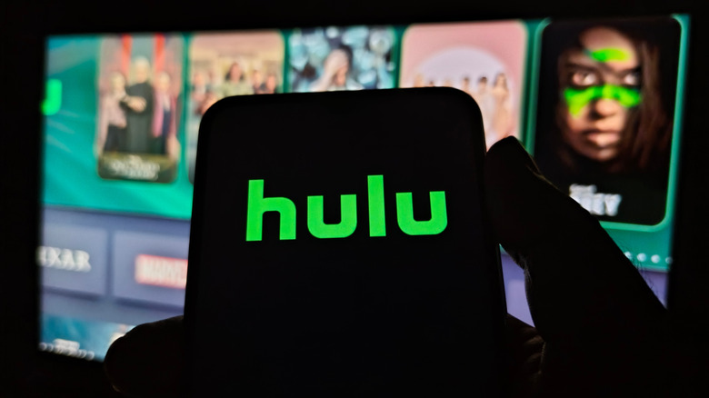 Hulu logo on phone in front of Hulu app on TV