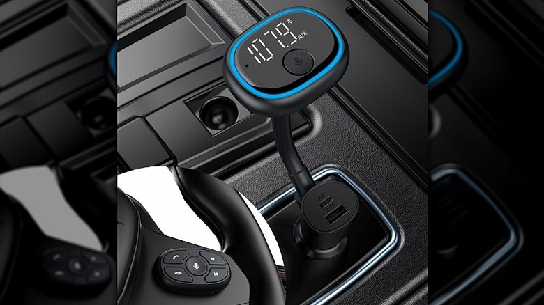 FM transmitter plugged into the car's port with a blue ring light on the top.