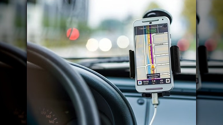 Phone displaying maps mounted on a car mount holder.