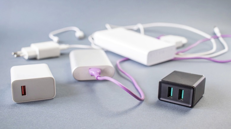 Cluttered charging bricks and power banks against a gray background