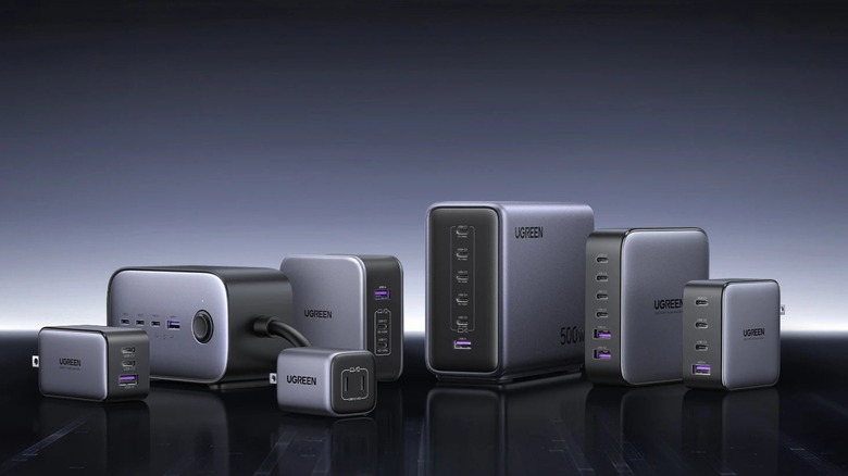 Ugreen Nexode series chargers on a black surface against a graded gray-back background