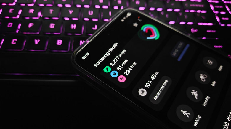 A Samsung phone opened to the Samsung Health app resting on a computer keyboard.