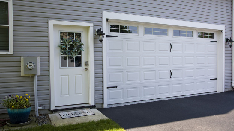 Exterior of a gray house with a white door and two car garage